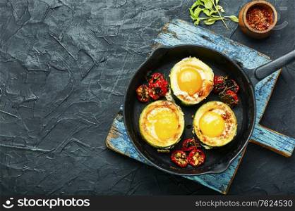 Fried eggs with cherry tomatoes in frying pan.Fried eggs in cast iron frying pan. Scrambled eggs on frying pan