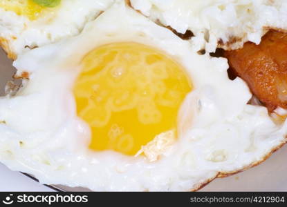 Fried eggs with meat and salad on the dish