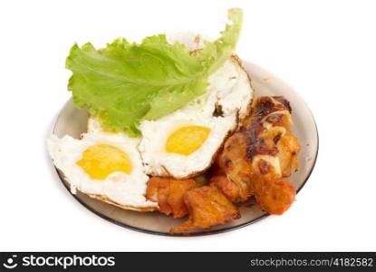 Fried eggs with meat on the dish isolated on white