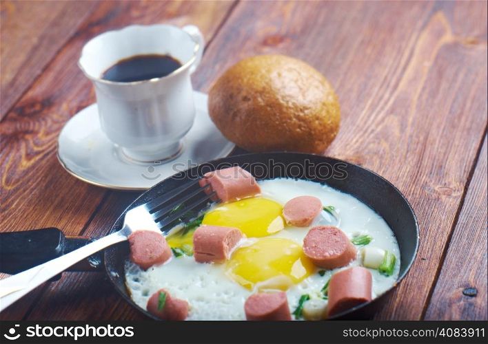 fried eggs with sausages and a cup of coffee .breakfast bachelor