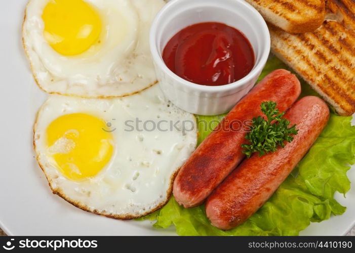 Fried eggs with sausages, toasts, greens and sauce