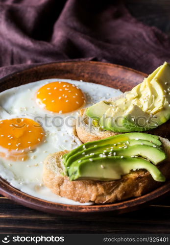 Fried eggs with toasts and avocado