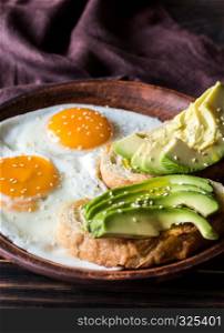 Fried eggs with toasts and avocado