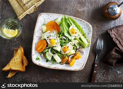 fried eggs with vegetables, top view, diet salad with quail eggs