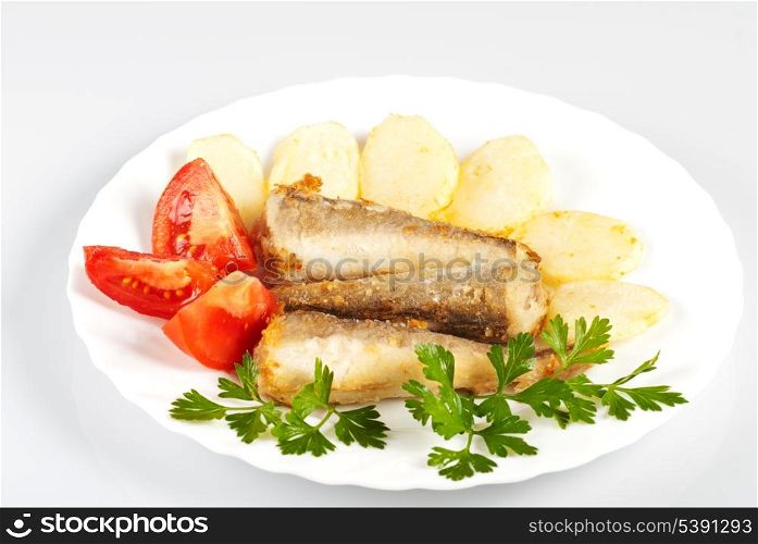 Fried fish and potato dinner on white