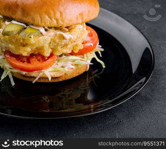 Fried fish fillet burger on black plate