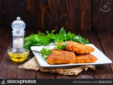 fried fish on plate and on a table