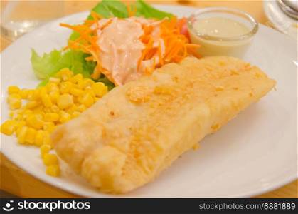 Fried fish steak with vegetables and corn