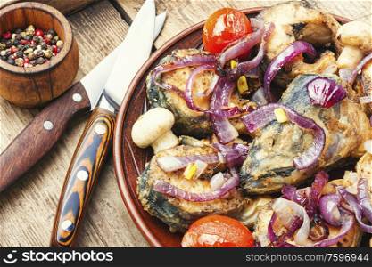 Fried fish with grilled vegetables on wooden table.Tasty and spicy fish. Piece of grilled fish