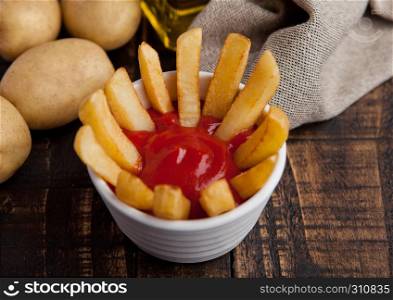 Fried french fries chips in fryer with ketchup on wood. Junk food