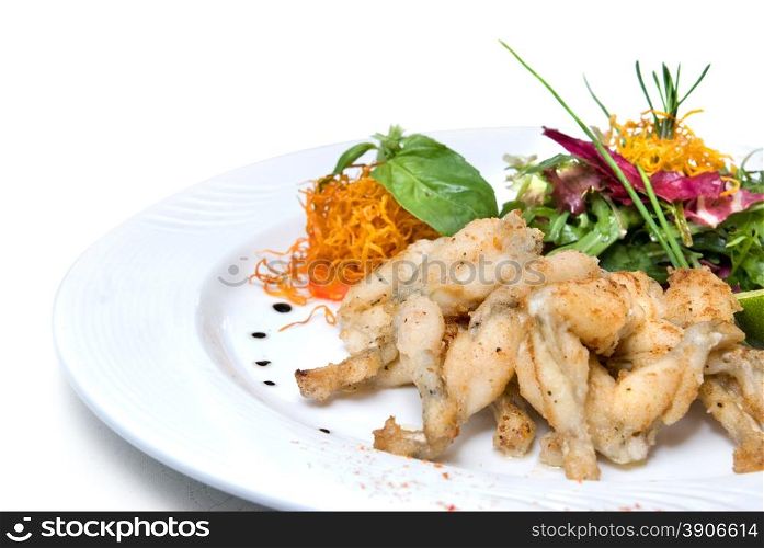 fried frogs legs on the plate isolated on white