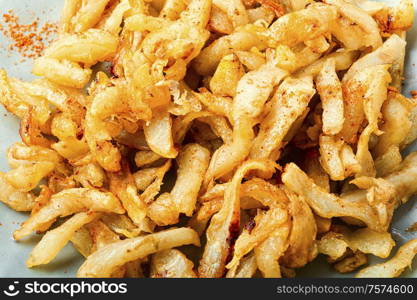 Fried Jerusalem artichoke roots or french fries.Food background. Fried Jerusalem artichoke on plate