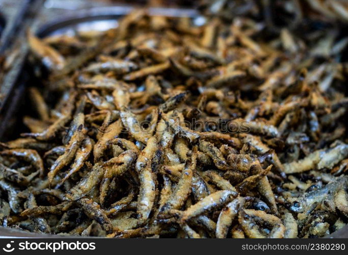 Fried little fish in market or food festival, food truck, food market. Live cooking station. Mixed deep-fried crispy fish seafood, street food