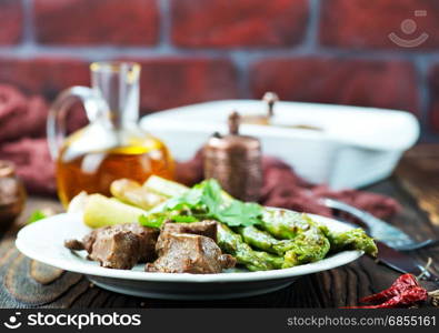 fried liver with asparagus on the plate