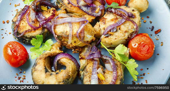 Fried mackerel with grilled vegetables on a plate.Roast fish. Mackerel fried in tomatoes