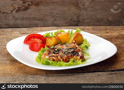 fried meat, baked potatoes and slices of tomato