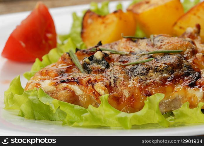 fried meat, baked potatoes and slices of tomato