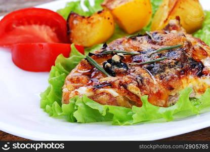 fried meat, baked potatoes and slices of tomato