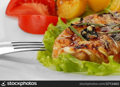 fried meat, baked potatoes and slices of tomato