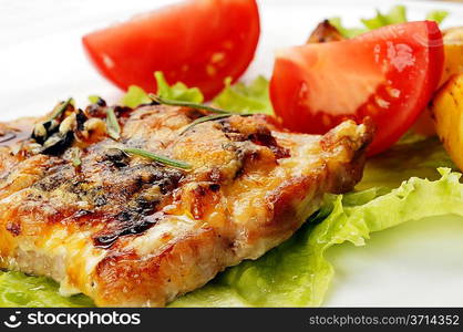 fried meat, baked potatoes and slices of tomato