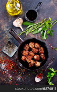 fried meat malls in pan and on a table