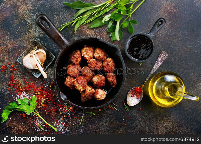 fried meat malls in pan and on a table