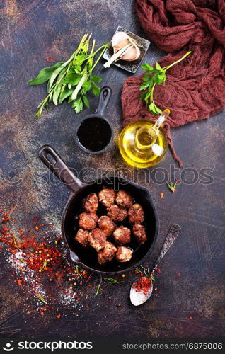 fried meat malls in pan and on a table