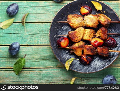 Fried meat on wooden skewers.Tasty kebabs in plum sauce. Kebab roasted with plum