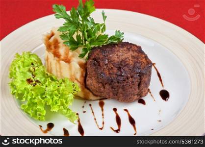 Fried meat steak with mashed potatoes, lettuce and greens