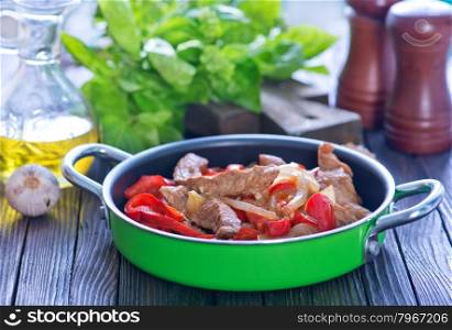 fried meat with pepper in the pan