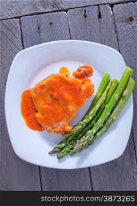 fried meat with sauce and asparagus