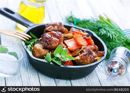 fried meat with vegetables in the pan
