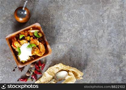 fried meat with vegetables in wooden bowl