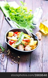 fried meat with vegetables on kitchen table