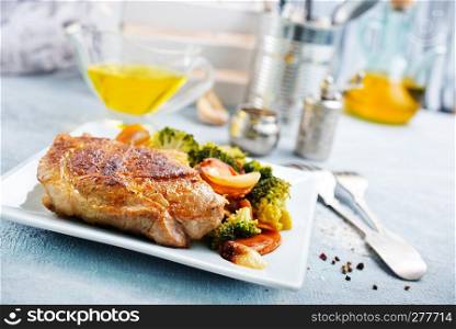 fried meat with vegetables on white plate