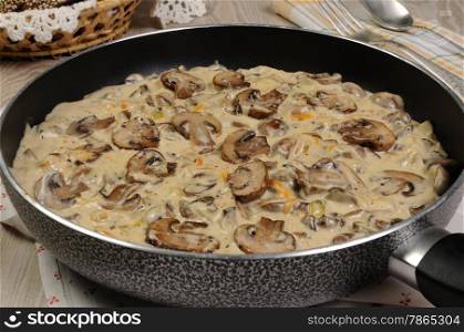 Fried mushrooms in a creamy sauce cooked in a frying pan
