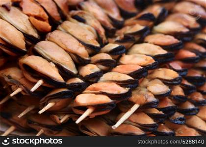 Fried mussels on skewers background