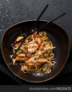 Fried noodles with chicken on top view