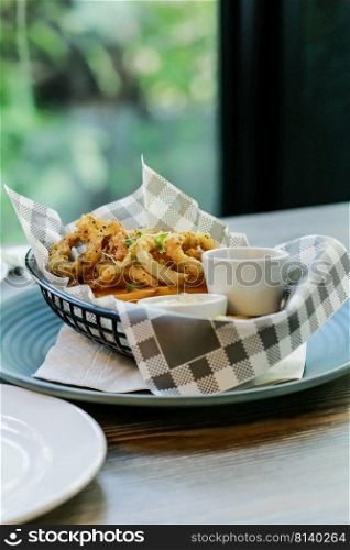 Fried onion rings with sauce in basket.. Fried onion rings.