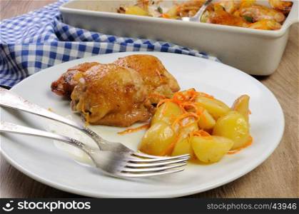 Fried pieces chicken with boiled potatoes and carrots on a plate