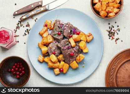 Fried pieces of beef and pumpkin.Veal meat with cranberry sauce.. Roasted beef with pumpkin