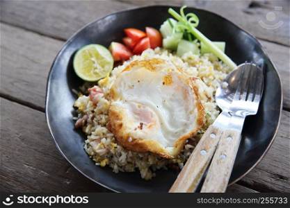 fried pork bacon rice with Poached egg on wood background Thai food