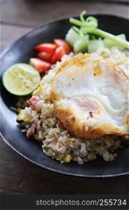 fried pork bacon rice with Poached egg on wood background Thai food