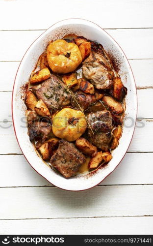 Fried pork meat with autumn quince.Grilled meat in baking dish. Stew pieces of meat with quince