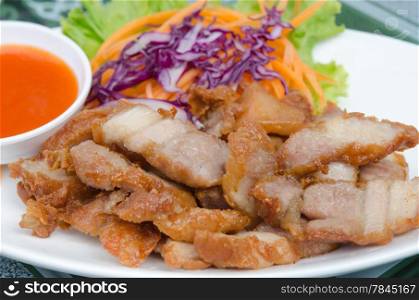 fried pork served with fresh vegetable and chili sauce on white plate