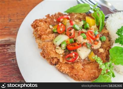 Fried pork with basil and jasmine rice on white plate