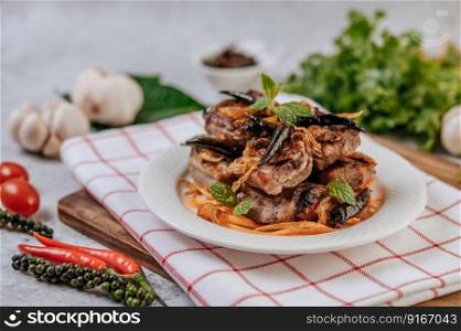 Fried Pork with Fried Chili Fried onion and mint in a white plate.