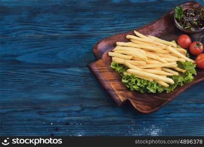 Fried potato at plate. Fried potato on a blue wooden background