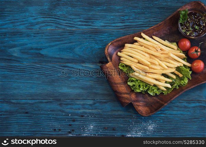 Fried potato at plate. Fried potato on a blue wooden background