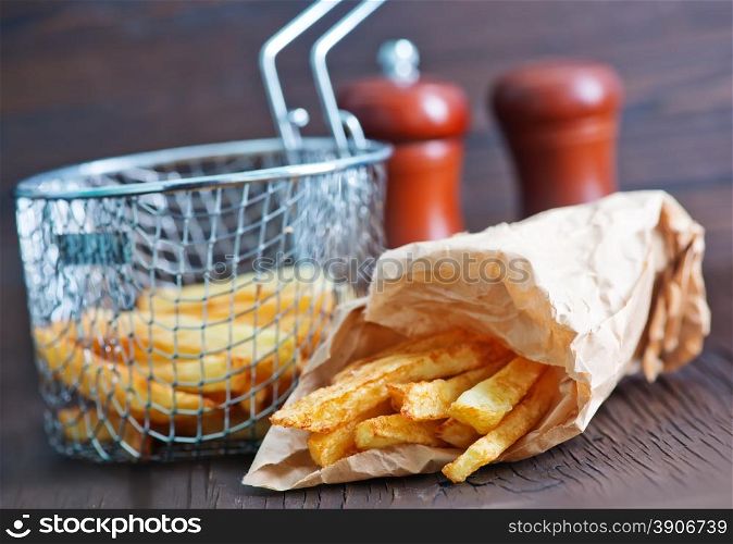fried potato in paper bag and on a table